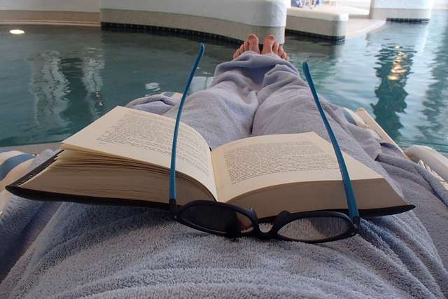 Buch und Sonnenbrille vorm Wasser