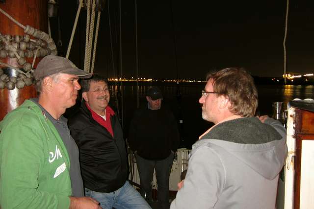 Tom, Ralf und Wolfgang vor beleuchtetem Kiel