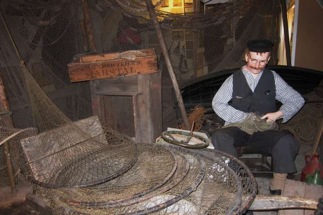 Fischer im Museum beim Ausbessern der Netze