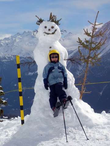kleiner Junge vor Schneemann
