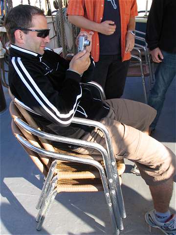 Mathias mit Fotoapparat auf Stuhlstapel