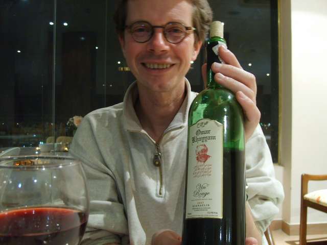 Helmut mit Weinflasche im Hotel