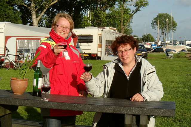 Anke und Jutta mit Wein am Campingplatztisch