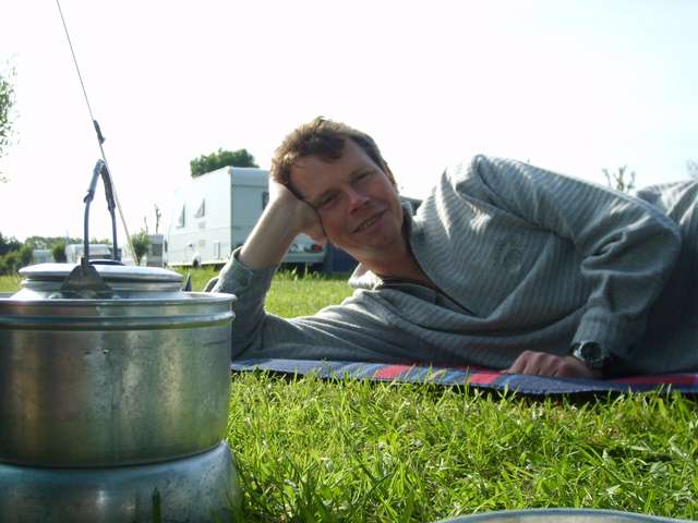 Helmut auf Campingmatte hinter Wasserkocher