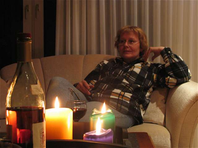 Anke auf der Couch hinter den Kerzen