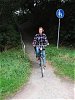 Anke kommt mit Fahrrad aus dem Wald