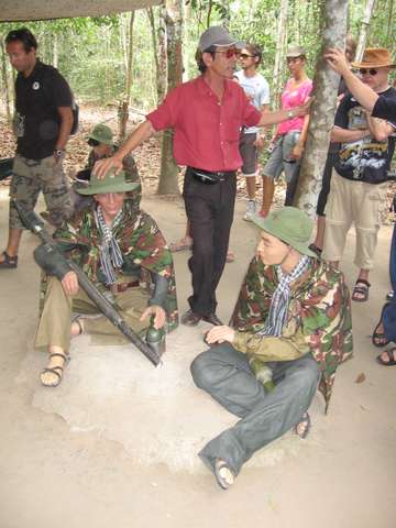 Reiseleiter mit Puppen von Widerstandskmpfern in Cu Chi