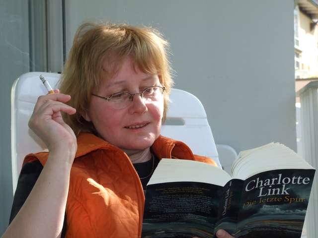 Anke mit Buch auch dem Balkon
