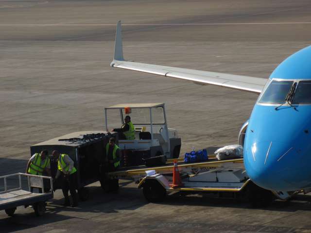 Tasche auf dem Förderband zum Flugzeug